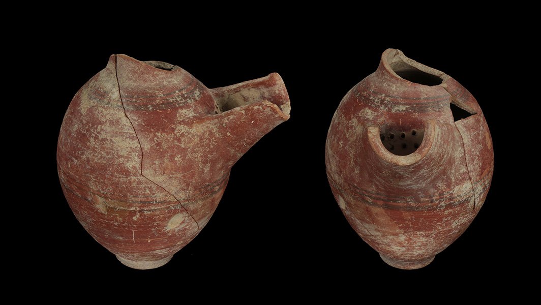 Photo shows two ceramic vessels on a black background. 