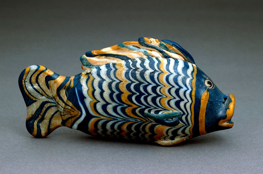 Photograph of a glass fish with wavy stripes of                white, blue and yelow.