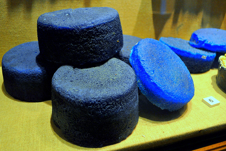 Photograph of about seven fat, blue disks of glass,                heaped in a pile.