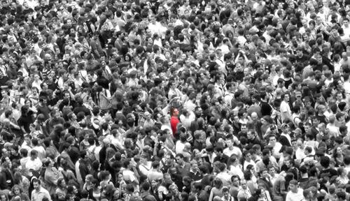 Photograph of a crowd of people with one individual highlighted