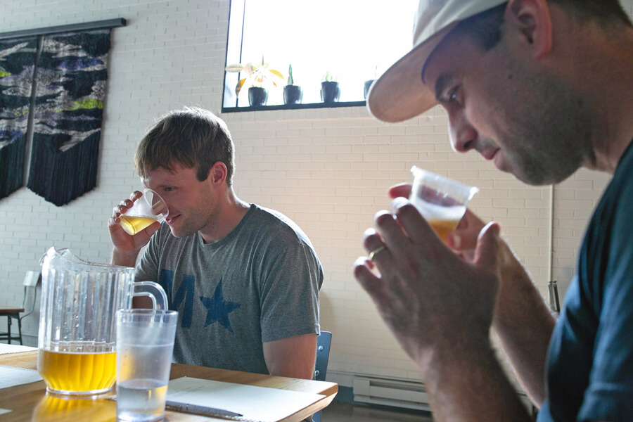 Photo shows two men drinking unlabeled beer. Blind taste tests have helped reveal the appeal of brands to consumers. 