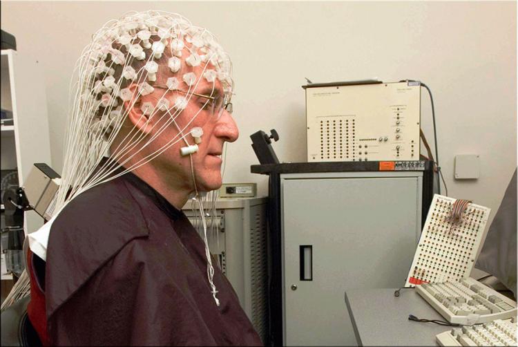 A man wearing an array of EEG sensors. 