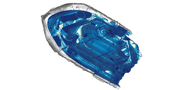 A cross section slice of a fragment of blue crystal edged in translucent gray.