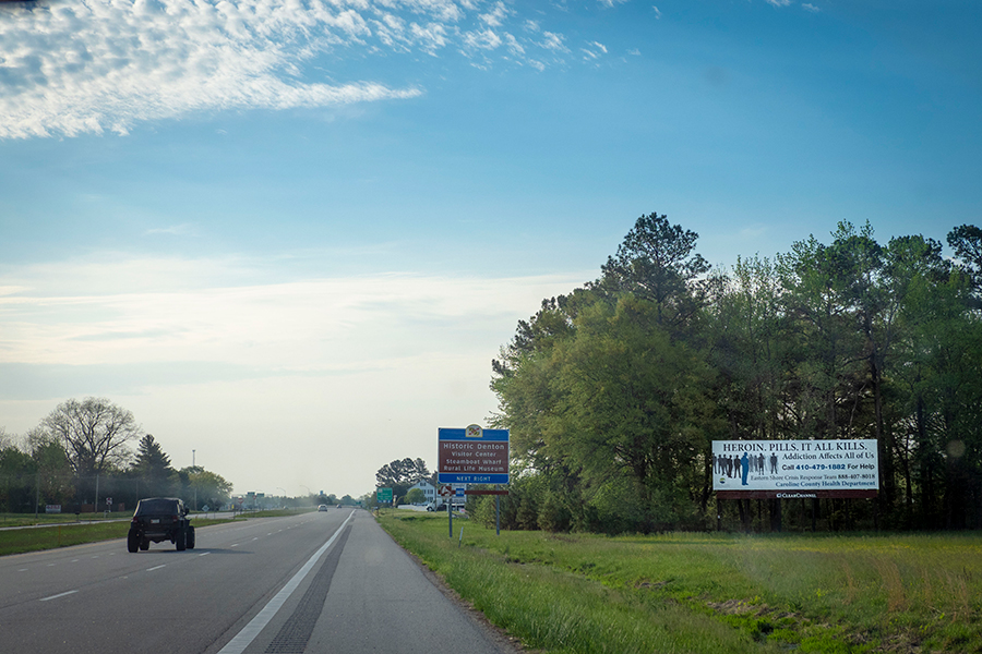 A highway at the outskirts of Denton, Maryland. A billboard warns of the perils of opioid addiction.