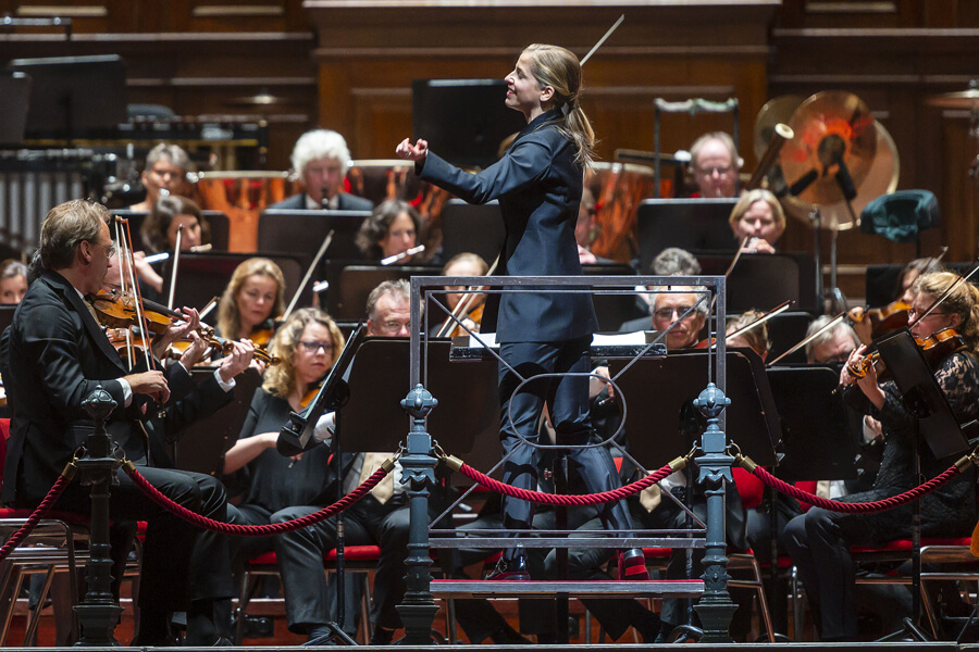 Photo shows US violinist and conductor Karina Canellakis performing with the Radio Philharmonic Orchestra in Amsterdam’s Concertgebouw.