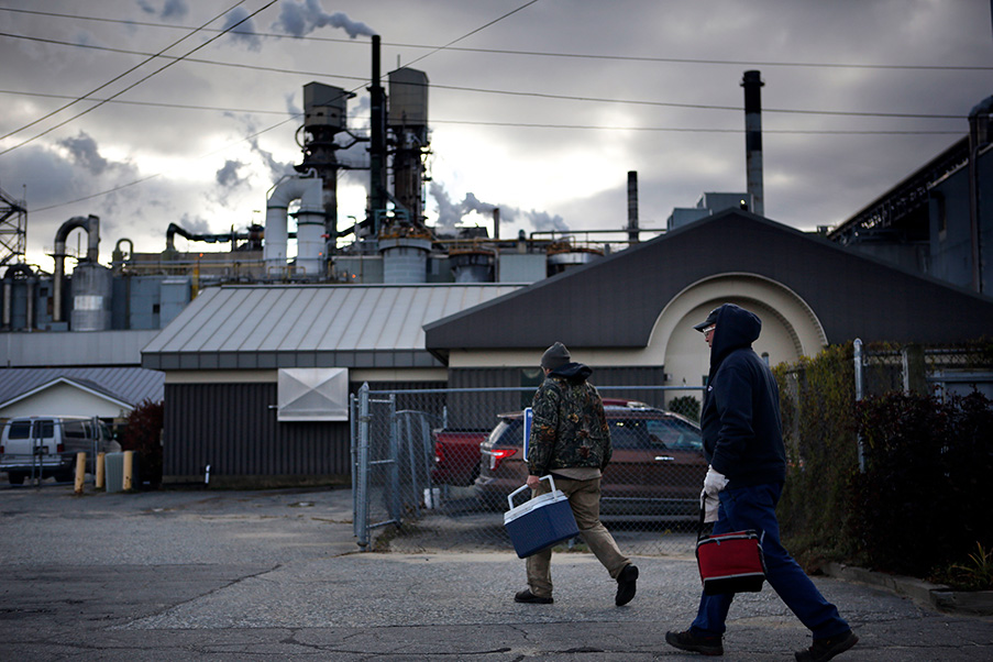 A photo shows workers leaving a paper mill at the end of their shift in Maine.