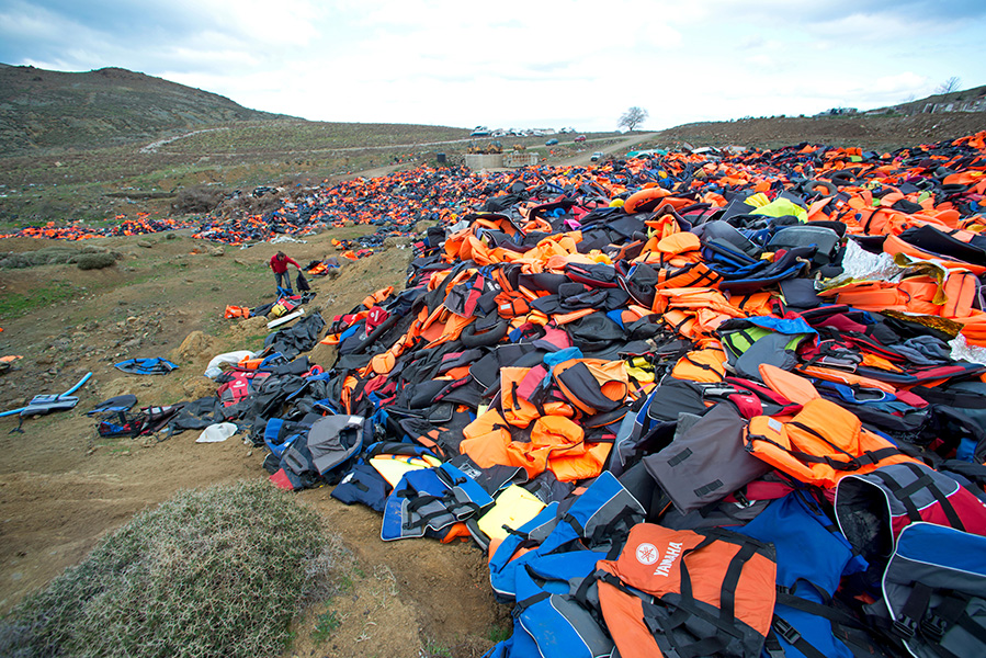 Photo of a pile of life jackets and other debris covering a hillside