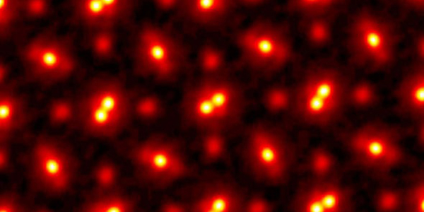 A grid of bright golden dots surrounded by red halos on a black background.