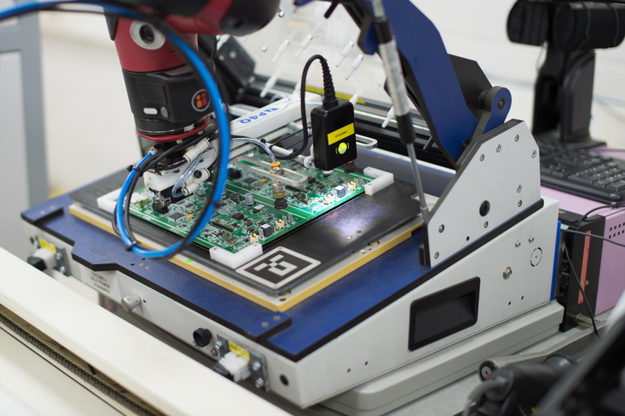 Photo shows precise work done by a cobot in the manufacture of a circuit board.