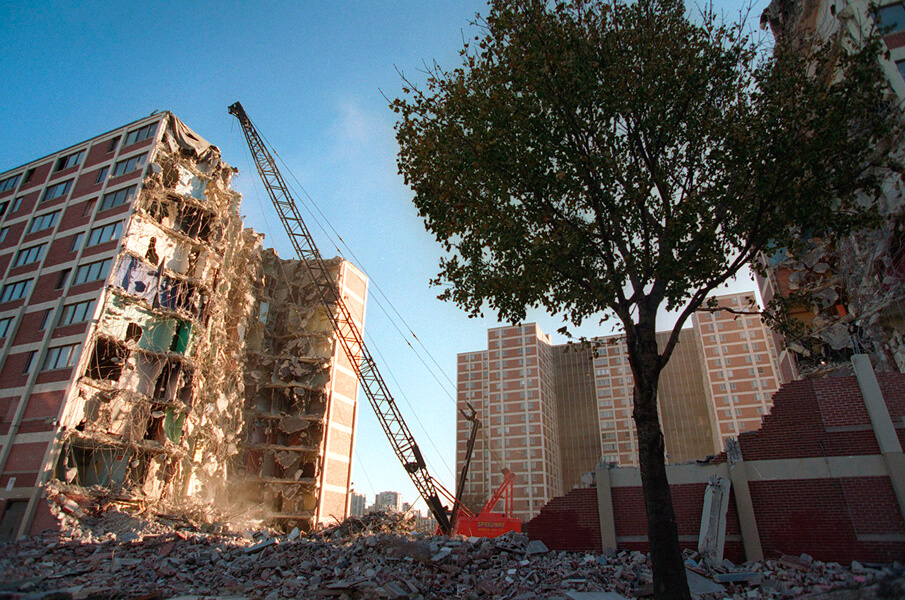 Photograph of a Chicago tower block being demolished. Replacing concentrated public housing such as this with more dispersed residences helped to reduce violent crime in the city.