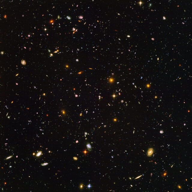 Photograph shows an array of galaxies in space. The Hubble Ultra Deep Field, is an image of a small region of space in the constellation Fornax, composited from Hubble Space Telescope data accumulated over a period from September 3, 2003 through January 16, 2004. The patch of sky in which the galaxies reside was chosen because it had a low density of bright stars in the near-field.