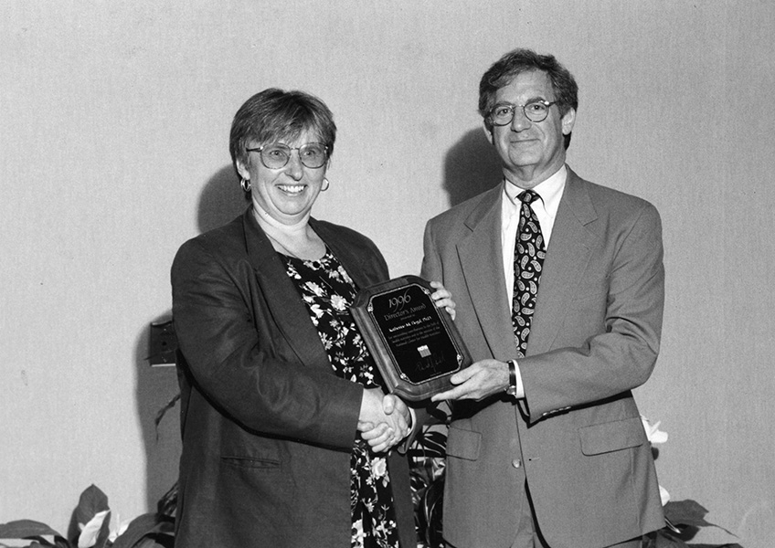 Photo shows Katherine Flegal receiving the Director’s Award from National Center for Health Statistics director Edward Sondik in 1996.