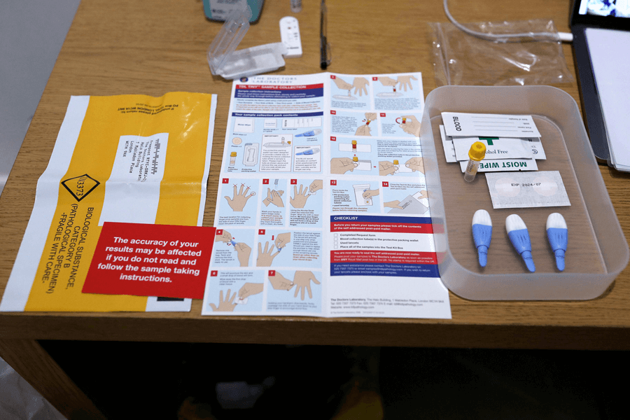 Photograph of an antibody test kit with instructions and other items laid out on a table.