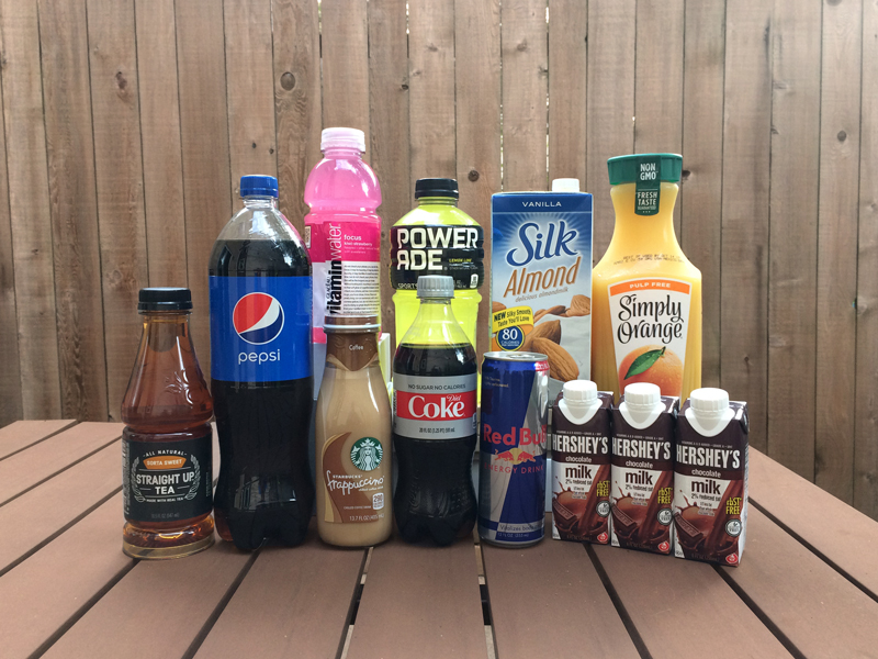 Photograph of a group of beverages in bottles and cartons, including soda, sports drinks, sweetened milks, coffee and tea.