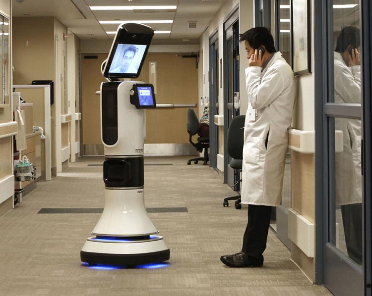 A doctor consults another provider via telepresence robot.