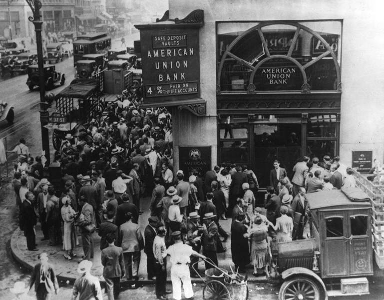 Historical photo shows a large crowd of depositors waiting outside the closed American Union Bank in New York City in 1932. Such runs on the bank were common in the Great Depression.