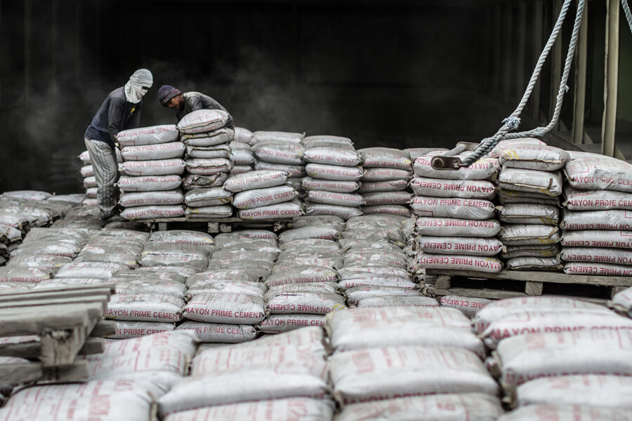 Photo shows workers loading bags of cement mix in the Philippines. 
