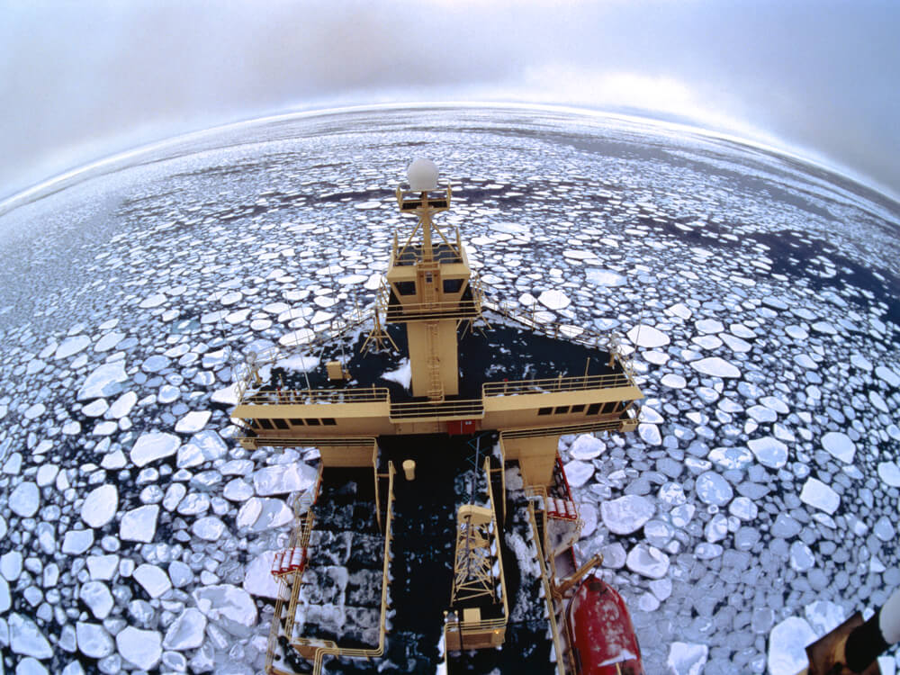 Bird’s-eye view of a ship surrounded by large slabs of pancake ice in the Arctic sea