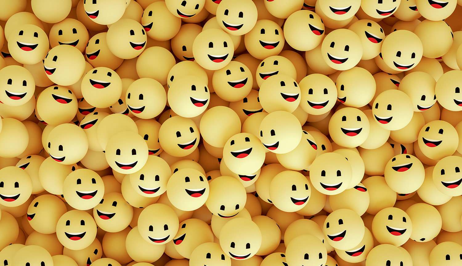 An array of yellow balls that have happy faces on them.