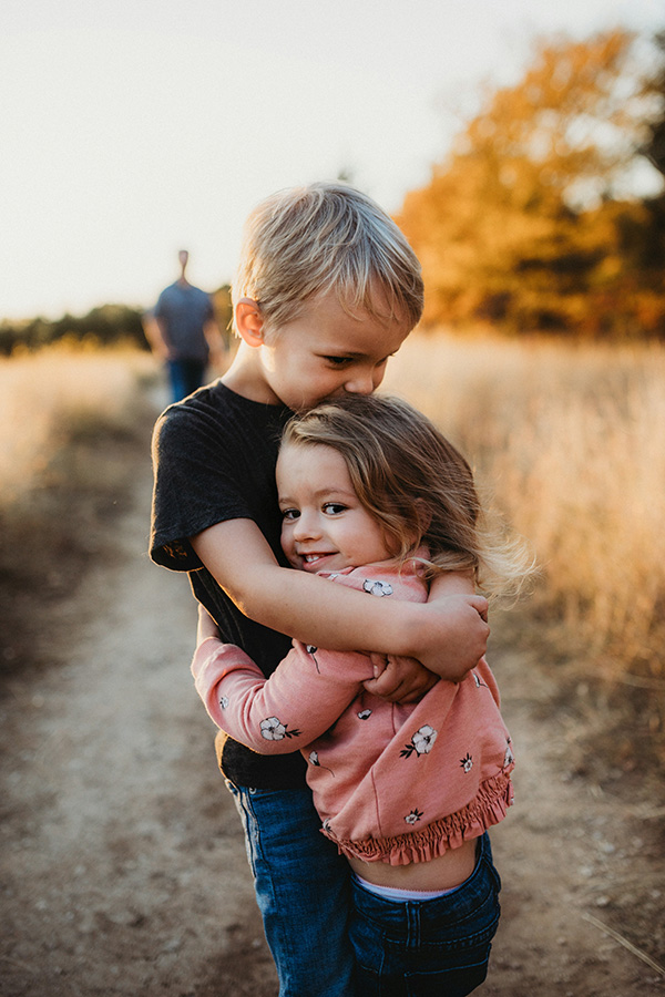 Photo of a brother and sister hugging each other.
