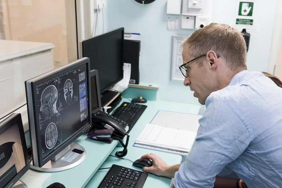 Photograph of Steve Fleming sitting at a computer console, looking at data.