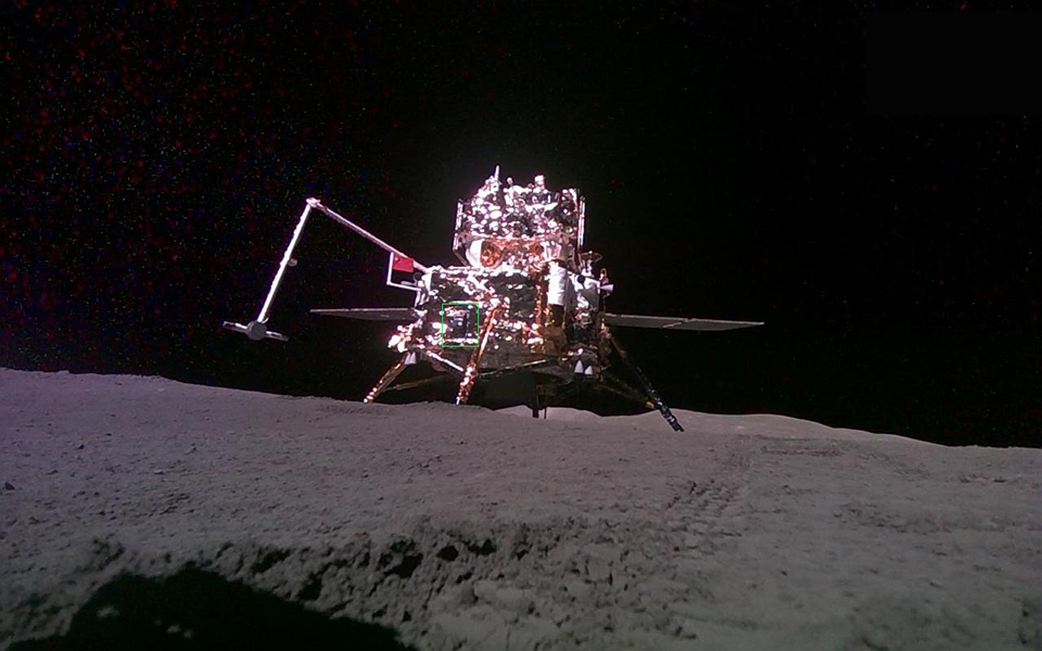 Image shows the spacecraft on a rocky surface with a dark sky above it.