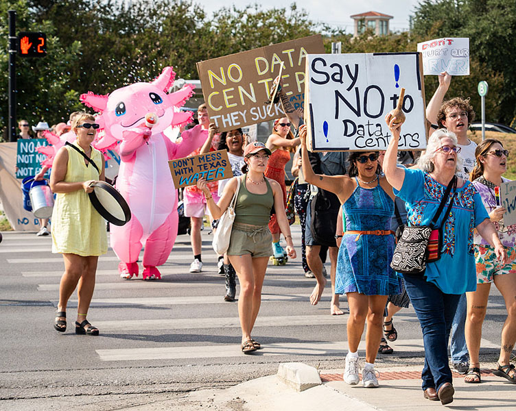 Anti-data-center protest Photograph of people marching in the street carrying signs that say things like “Say NO to data centers.”