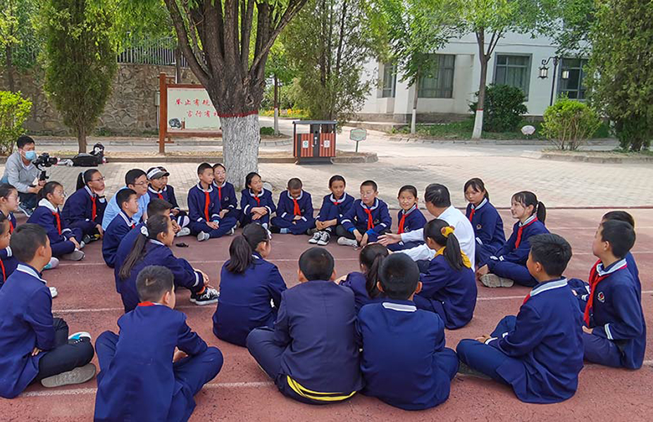 Chinese schoolchildren having a lesson outdoors.