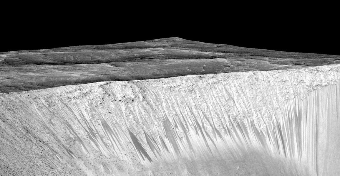 Image shows a pattern of darker lines on the face of a steep slope, with Martian plains and a dark sky in the background.