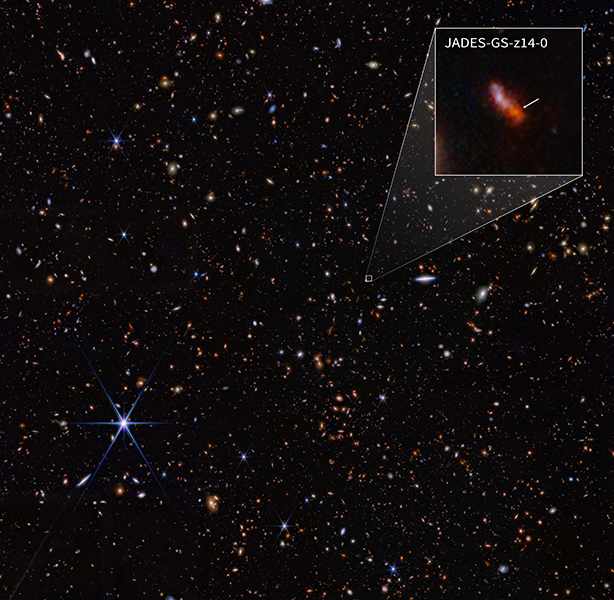 A black sky of a deep field view peppered with distant galaxies; a close up of the tiny, red and most-distant yet Jade galaxy.