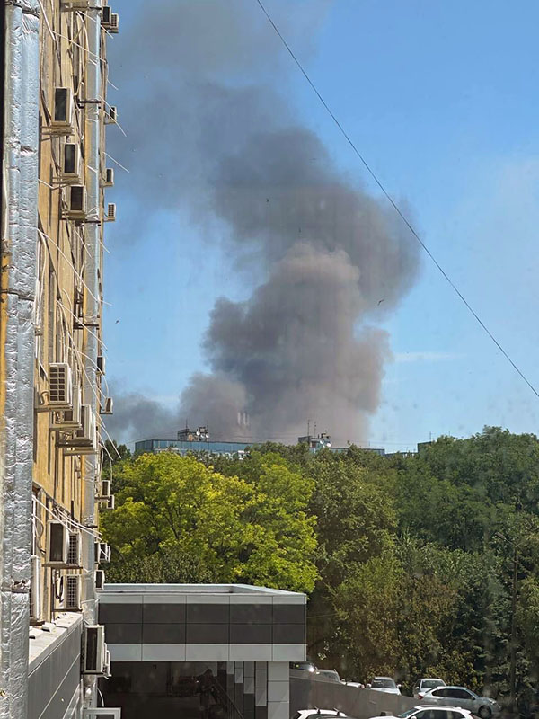 Missile strike A large dark cloud of dust and smoke fills the sky behind trees and a building.