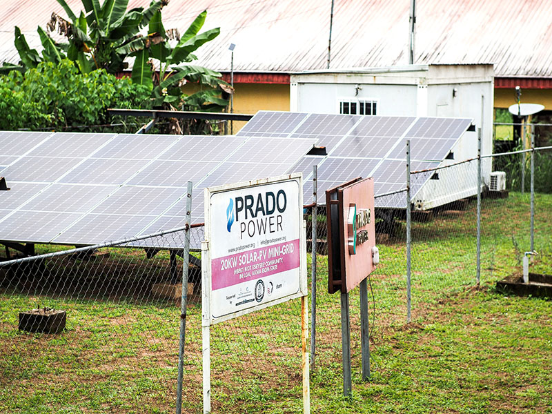 A photo of two solar panels behind a chain link fence, with a sign that reads “Prado Power.”