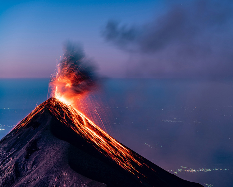 An erupting volcano, with lava spurting from its crater.